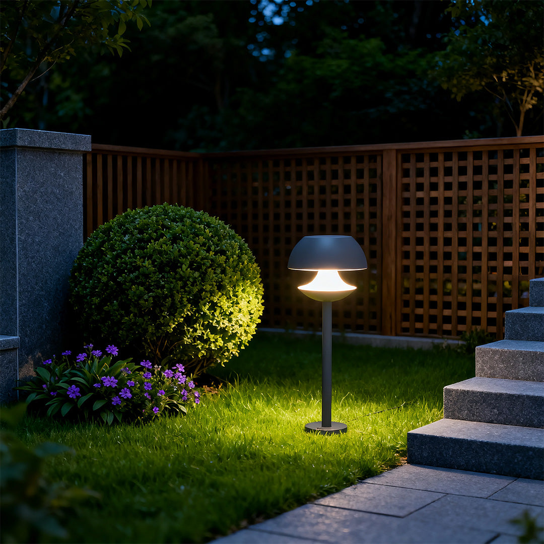 Multiple mushroom path lights creating ambient lighting in backyard garden with manicured lawn and shrubs.