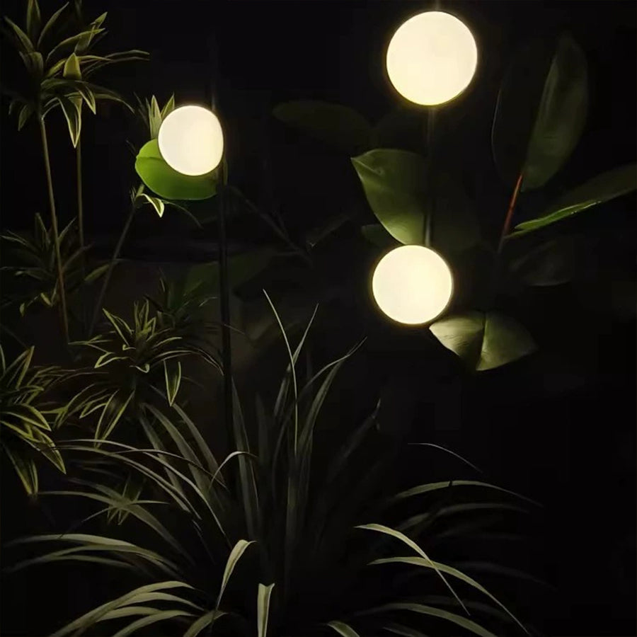 Multiple glowing orb lights creating magical evening atmosphere in lush garden landscape