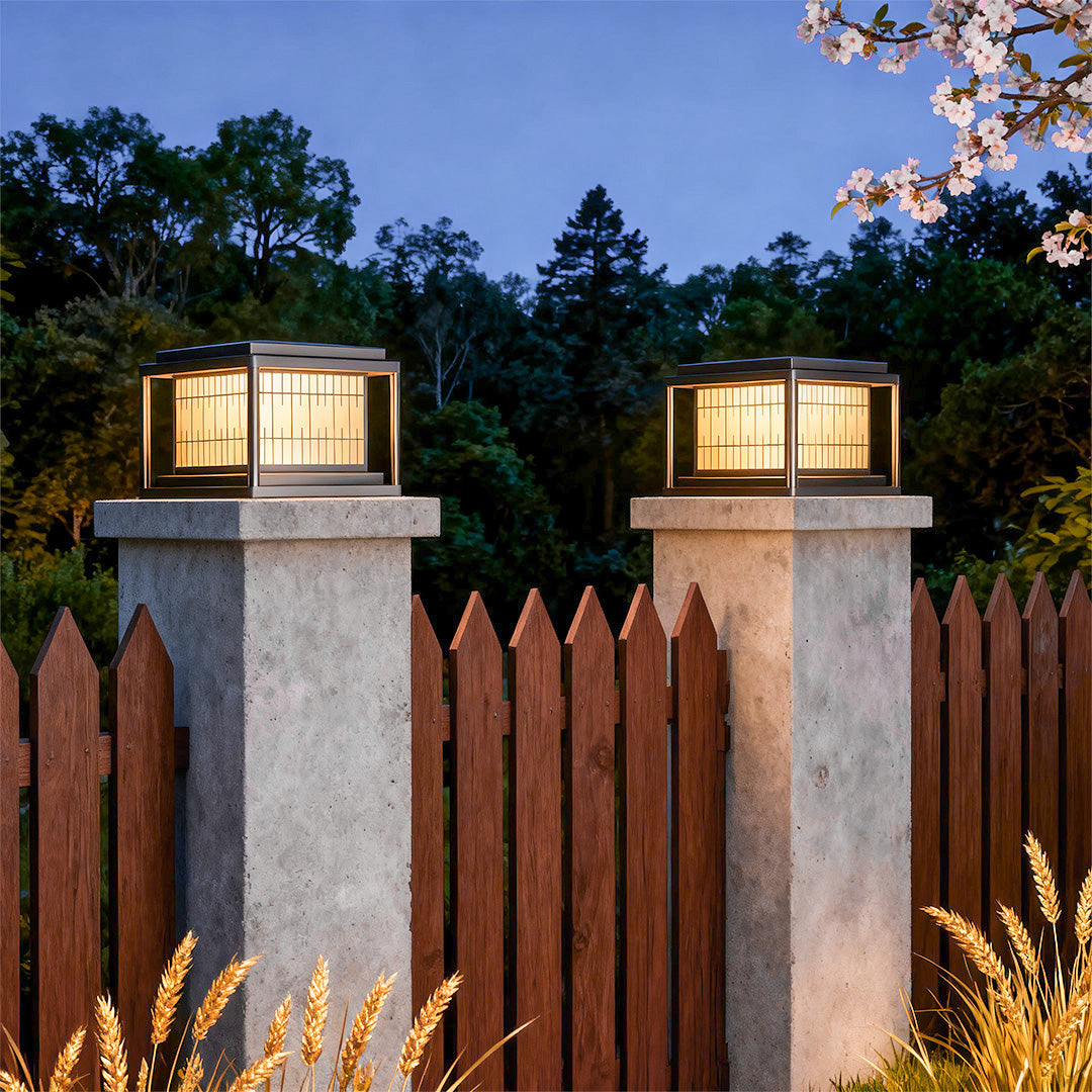Multiple outdoor pillar LED lights flanking residential entrance with wood fence and landscaping at twilight.