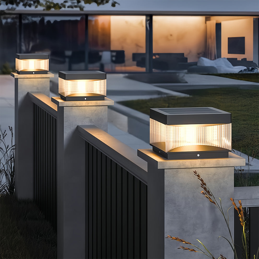 Multiple square pillar lights adorning contemporary residential deck railing at dusk