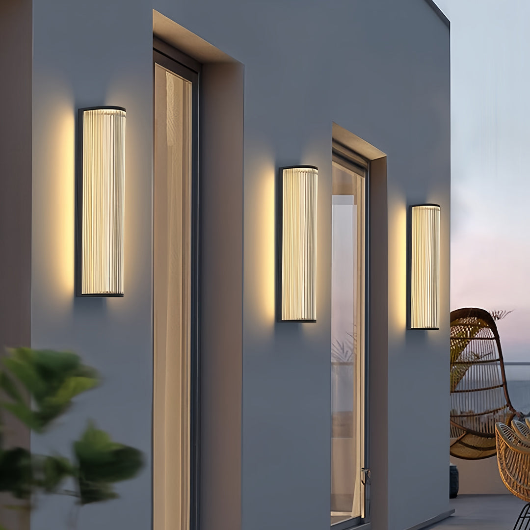 Multiple stylish vertical wall sconce lighting fixtures providing ambient light on a modern building facade.