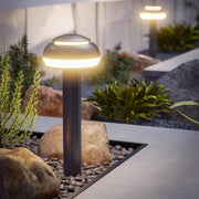 Mushroom path light installed in a garden, providing warm and inviting illumination.
