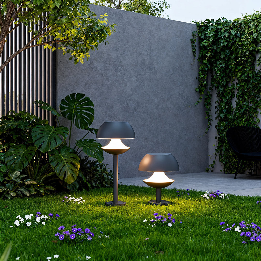 Mushroom path lights illuminating garden pathway at dusk with lush greenery and modern landscaping.