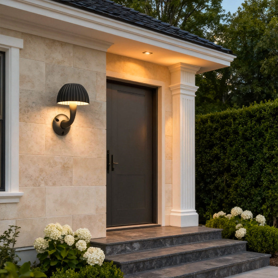 Mushroom wall light installed beside a home entrance, highlighting the textured exterior façade.