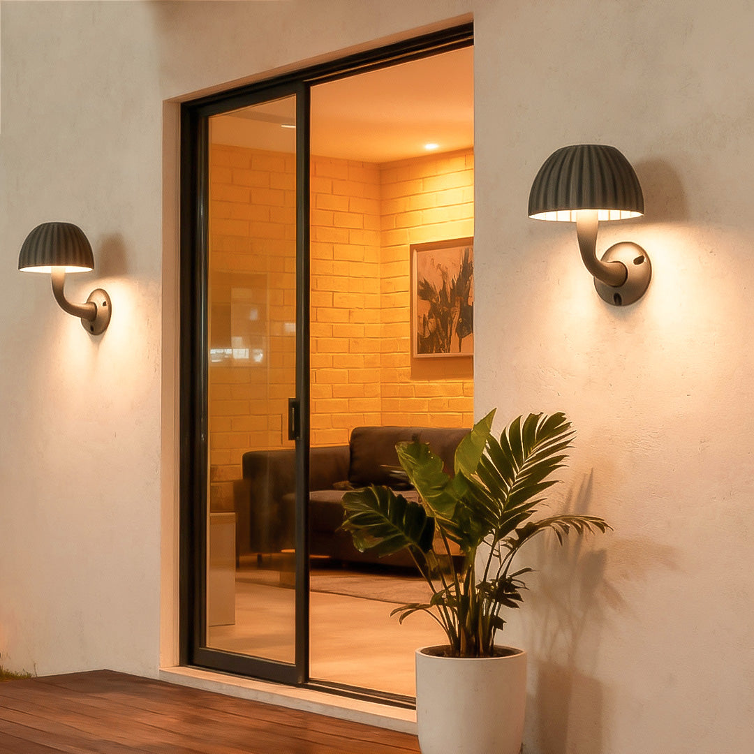 Warm-lit mushroom wall light illuminating a modern patio entrance with a cozy ambiance.