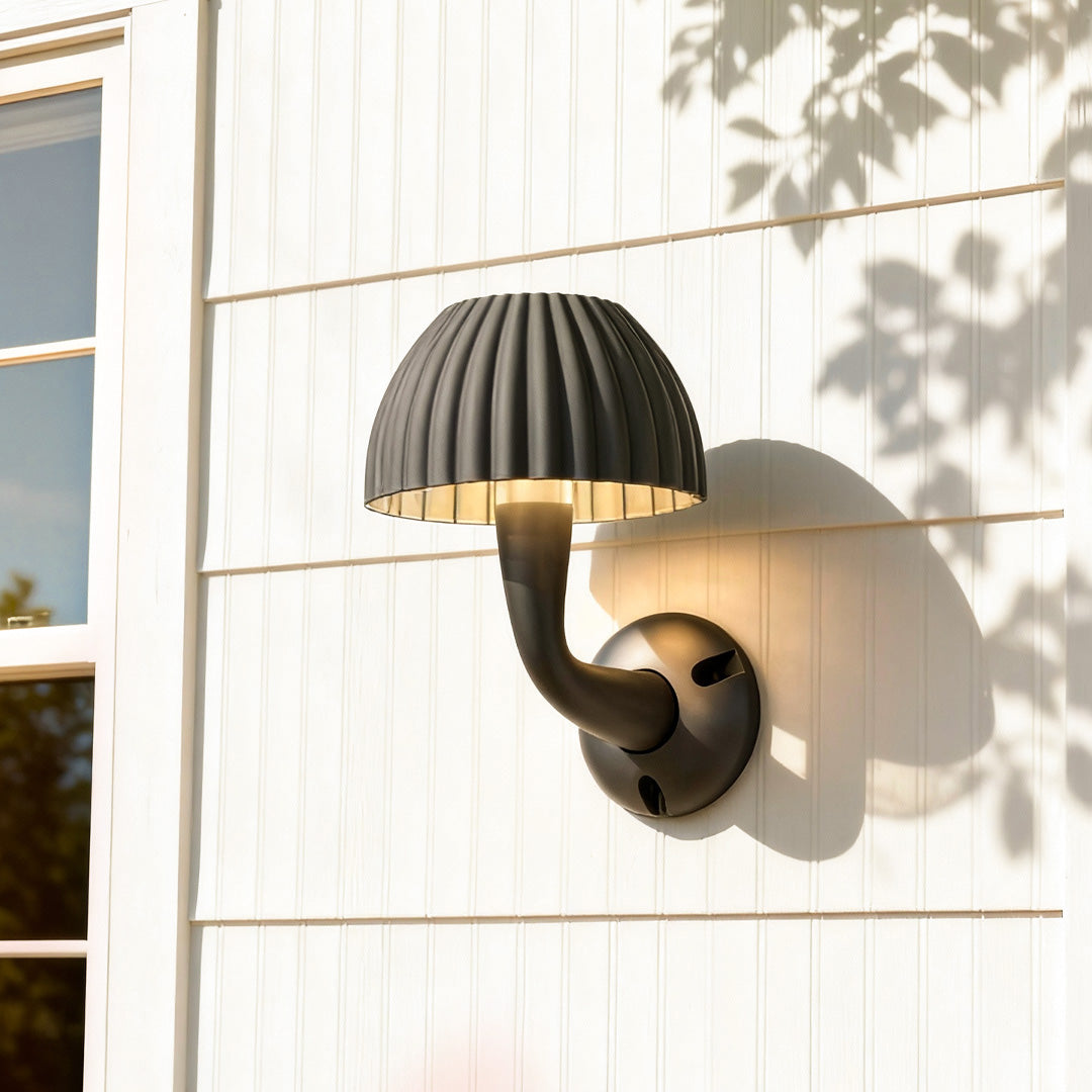 Outdoor mushroom wall light mounted on a white exterior wall, casting a warm downward glow.