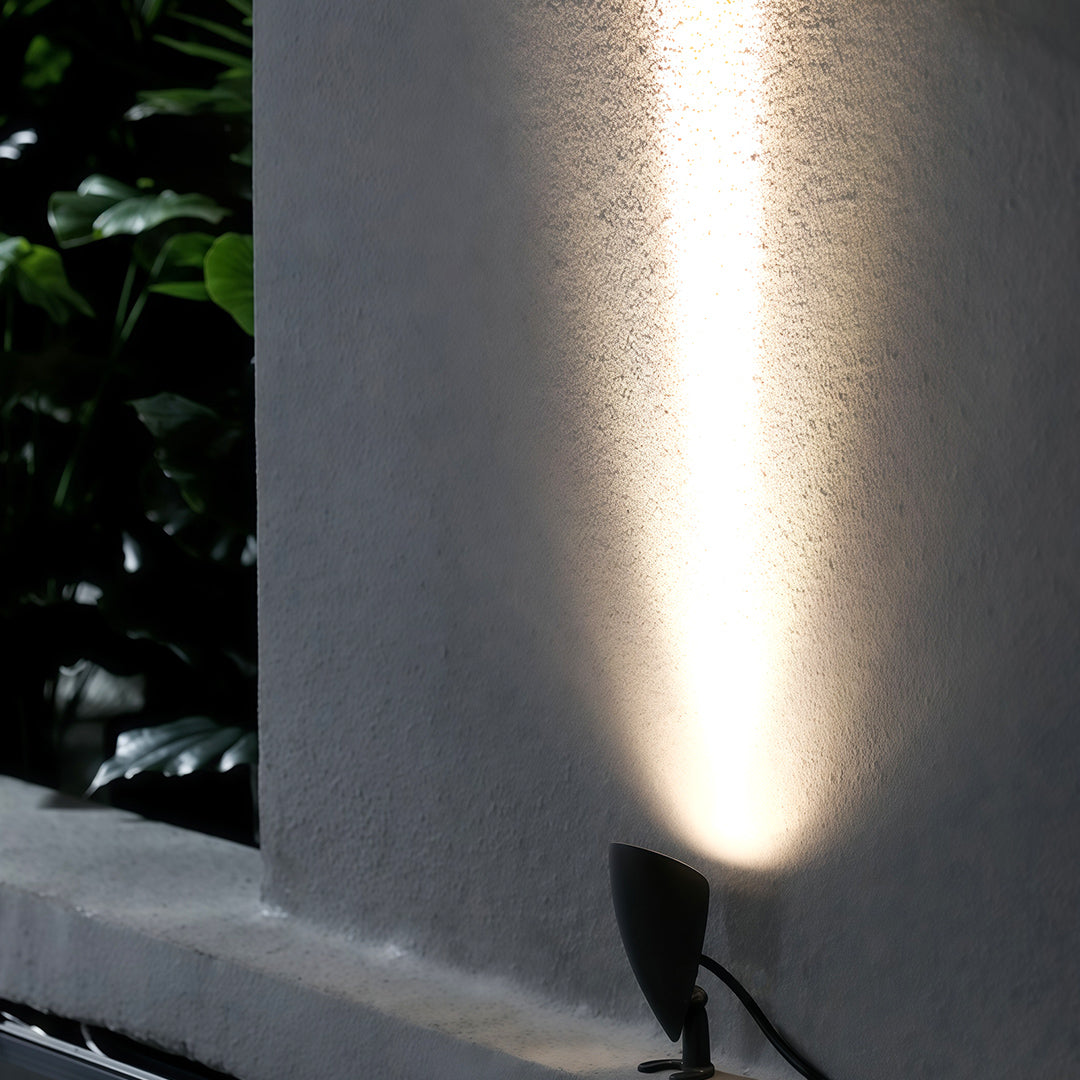 Narrow beam of light projected upward by a small decorative wall washer.