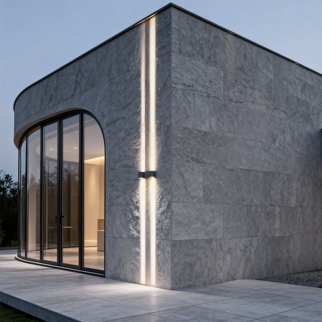 Minimalist narrow beam wall sconce creating focused vertical light lines on modern exterior wall.