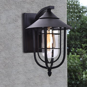 Black metal nautical wall sconce mounted on exterior wall, featuring a cage design and warm filament light.