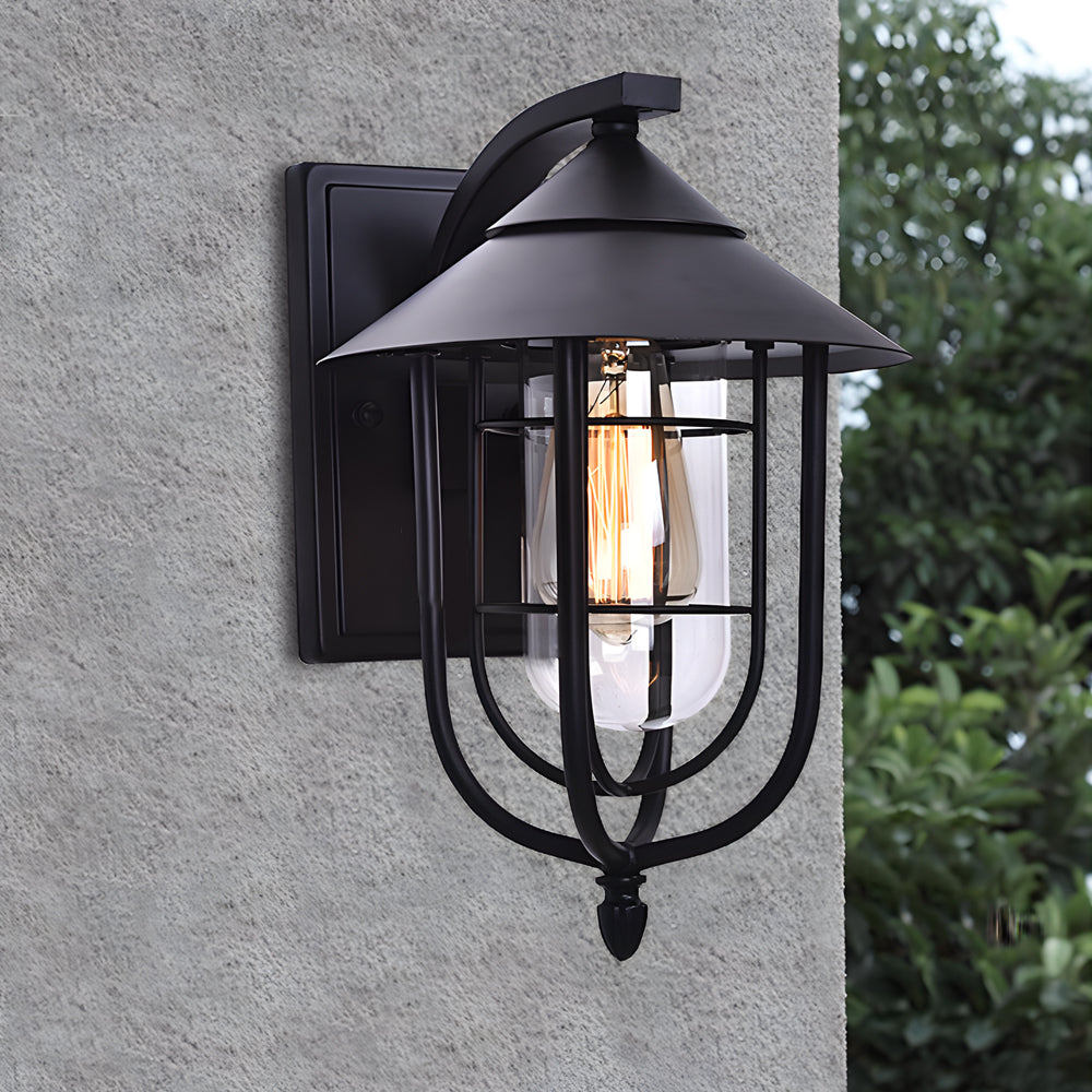 Black metal nautical wall sconce mounted on exterior wall, featuring a cage design and warm filament light.