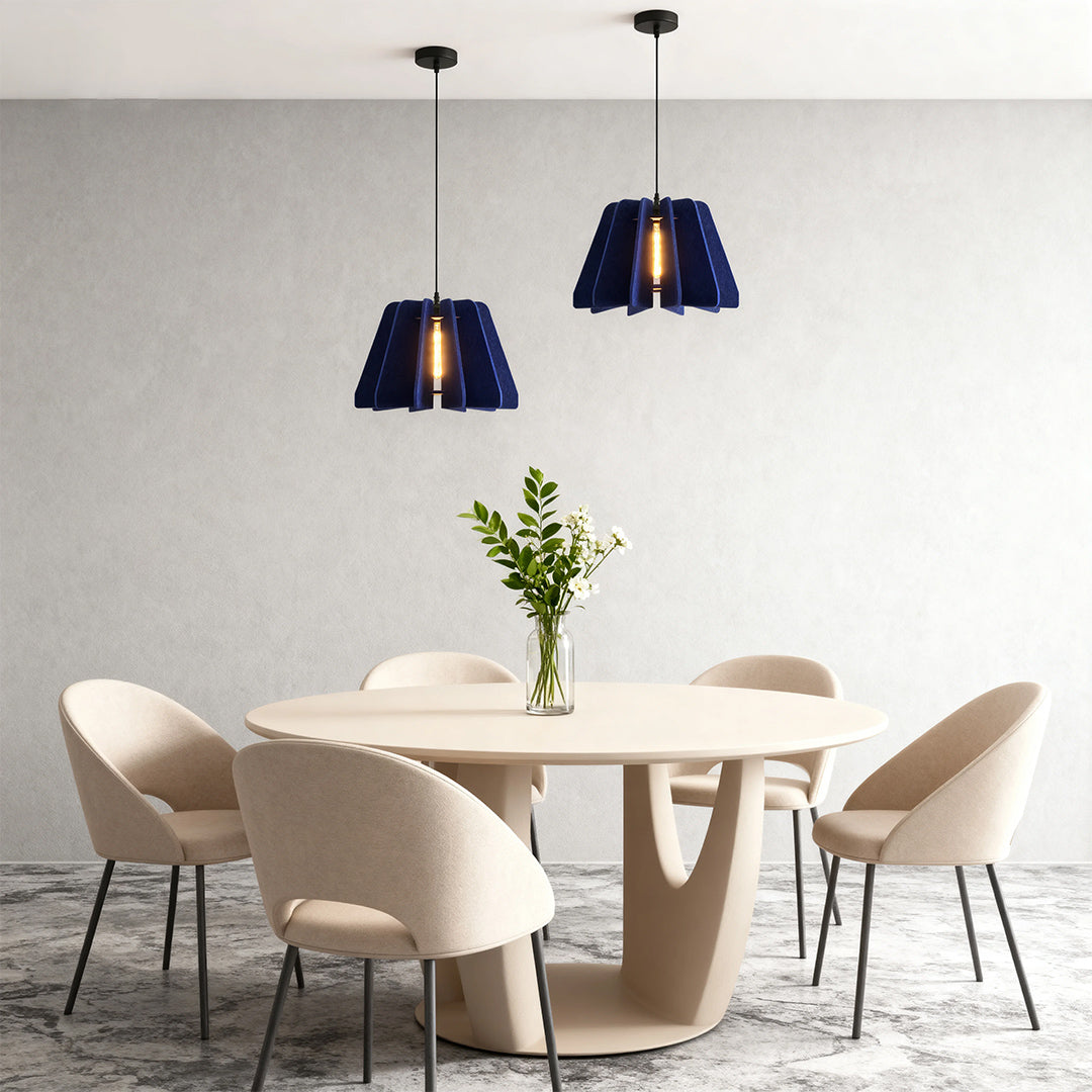 Two navy blue felt 1 light single pendant lamps elegantly suspended over a minimalist round dining table.