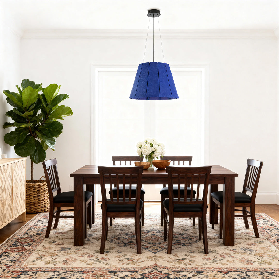 Navy blue felt industrial pendant light fixture hanging over a classic dark wood dining table in a cozy modern room. 
