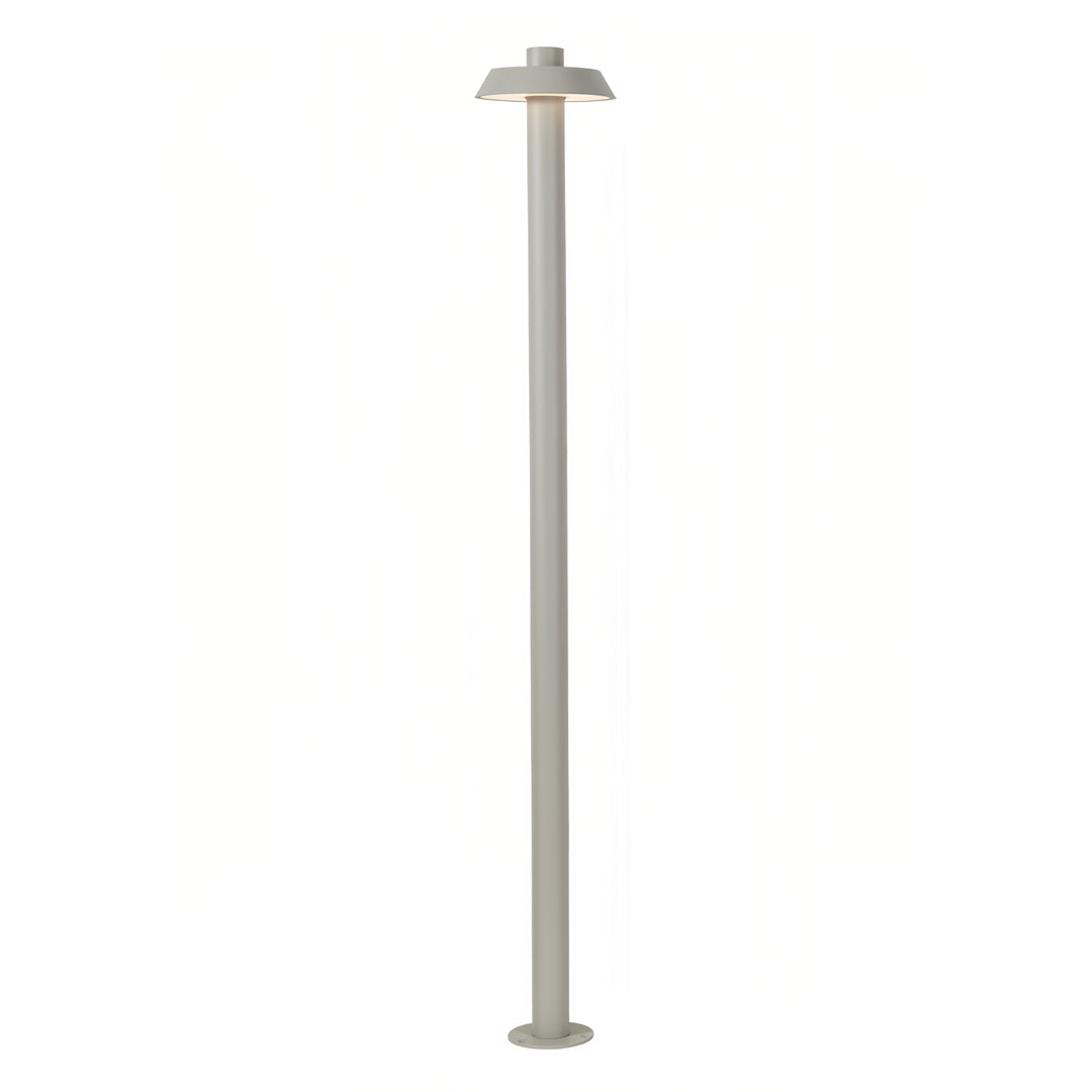 Outdoor nighttime scene with bronze aluminum path lights illuminating gravel and garden plants.