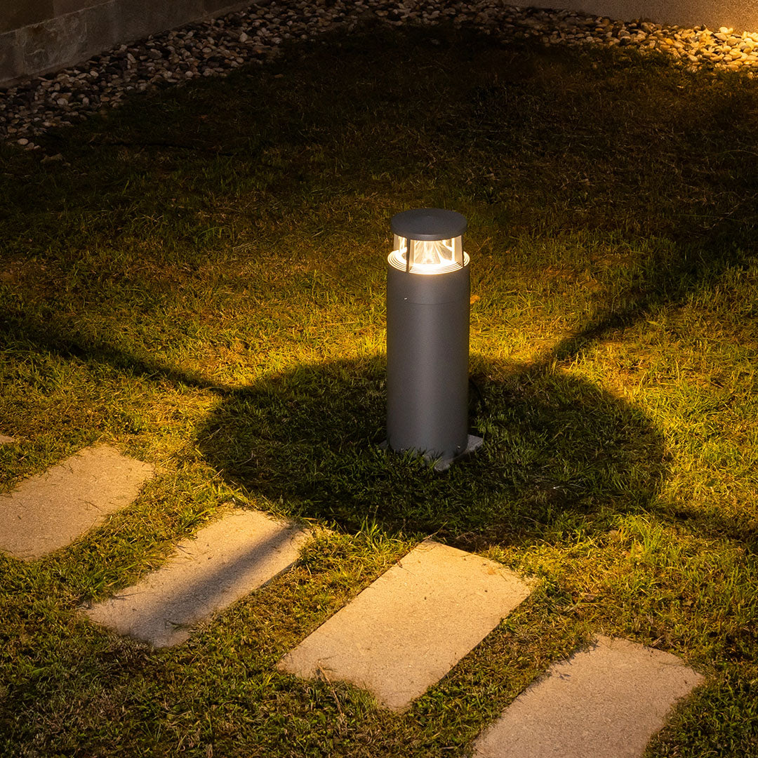 Nighttime garden scene featuring multiple bollard lights creating dramatic lighting effects on lawn
