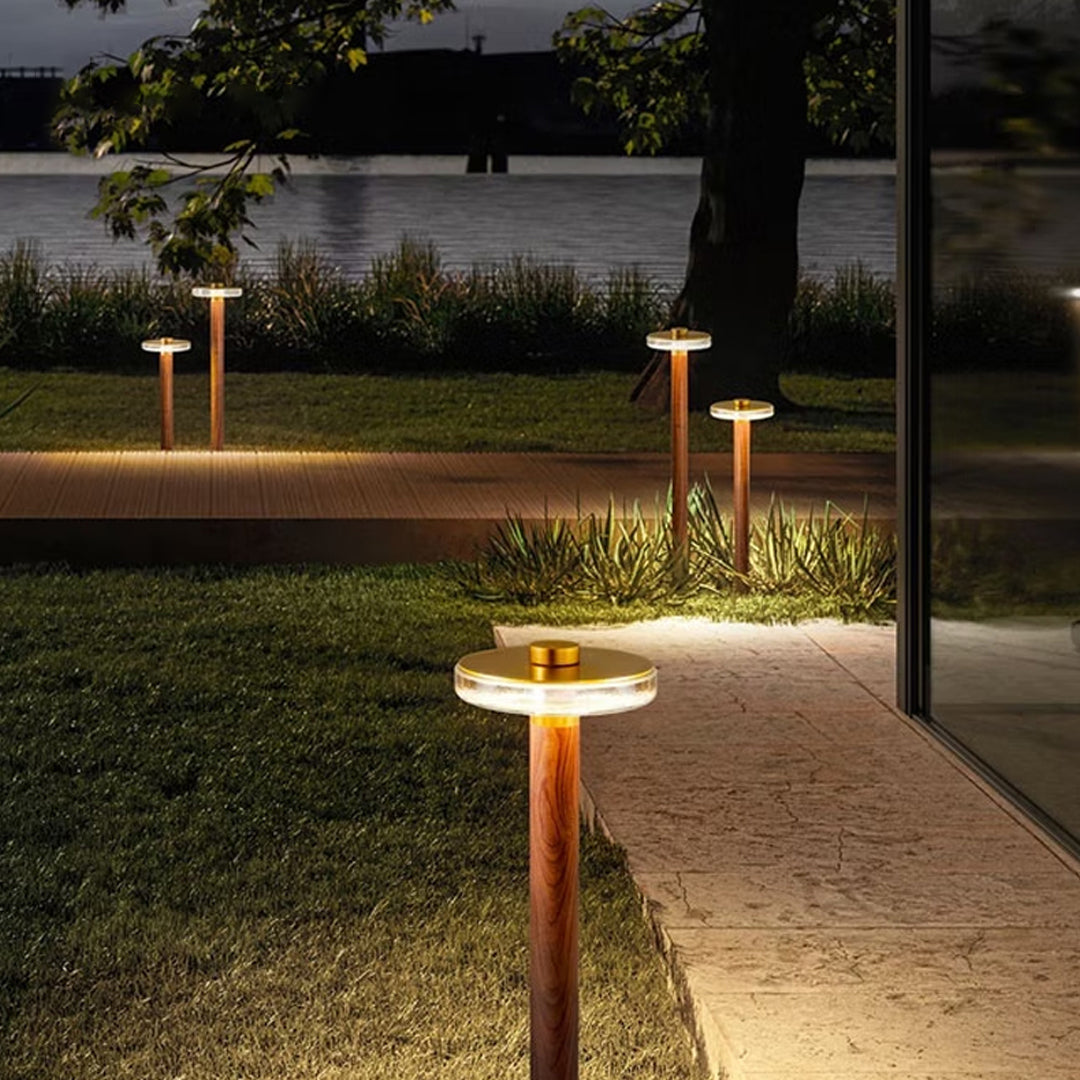 Warm glowing landscape pathway lighting lining a curved nighttime garden walkway.