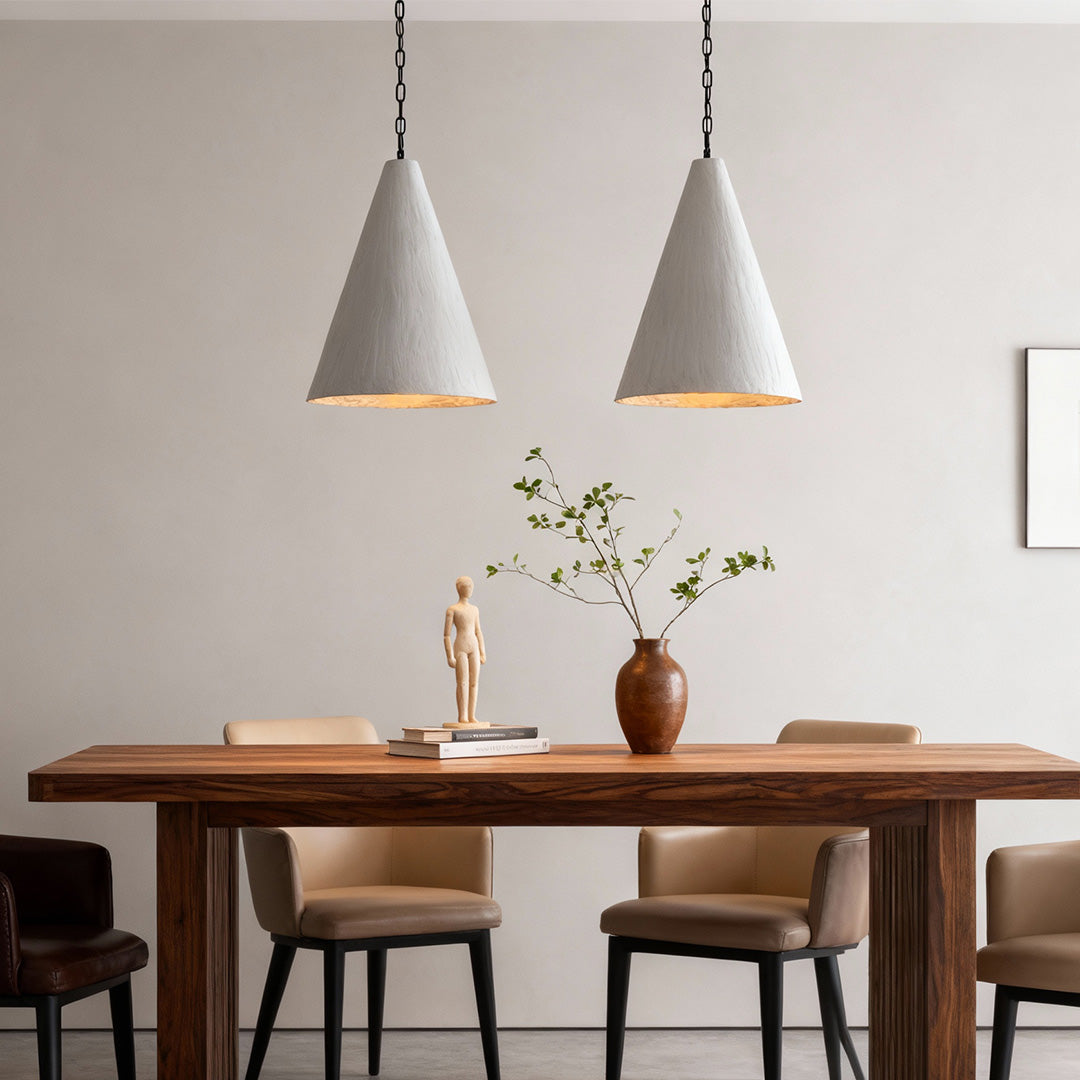 Pair of Nordic style pendant lights hanging above dining table, creating warm and cozy dining space.