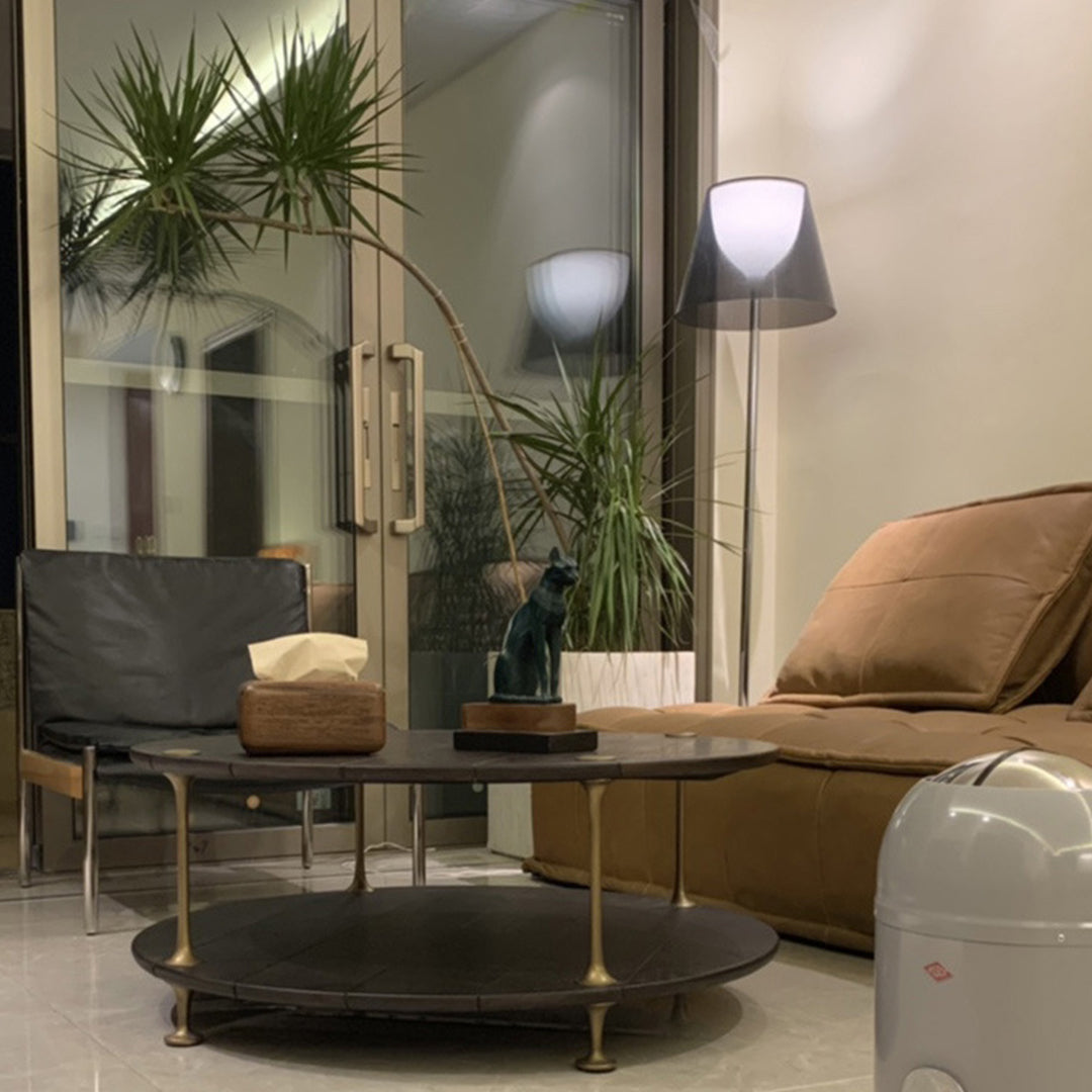 Nordic floor lamp in cozy living space with brown leather furniture and natural plant elements