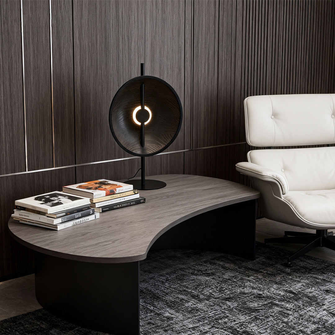 Natural oak table lamp with minimalist circular wood shade and black stand.