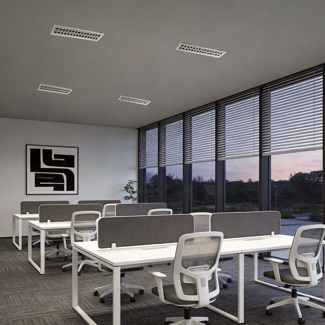 Office space with multiple desks illuminated by led ceiling recessed spotlights.