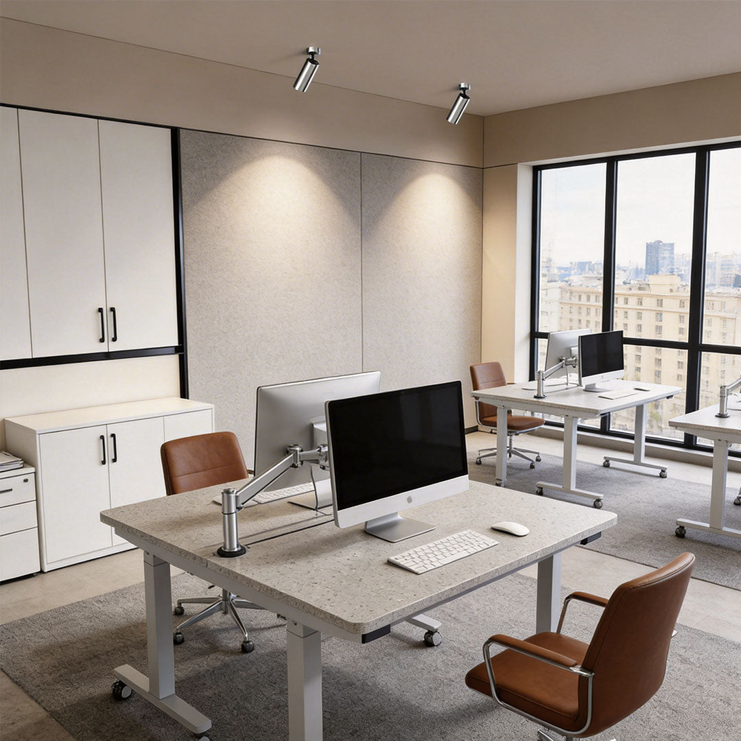 Contemporary office space with spotlight light fixture highlighting workstations.