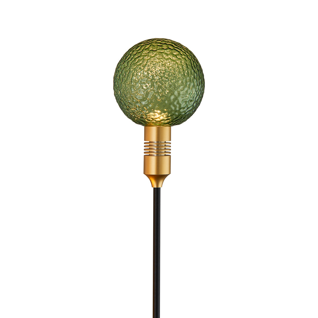 Olive-green crackle-glass path stake light adding soft color and glow to landscape lighting.