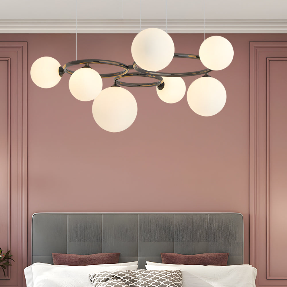 Opal glass globe chandelier with a black frame, illuminating a contemporary living room.