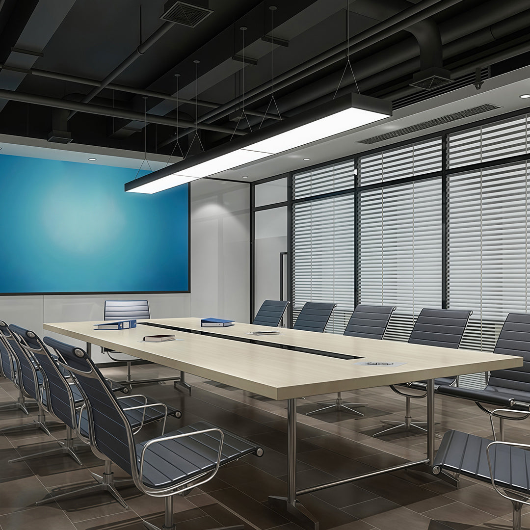 Long rectangular chandelier suspended in an open office space, combining functionality with a sleek design.