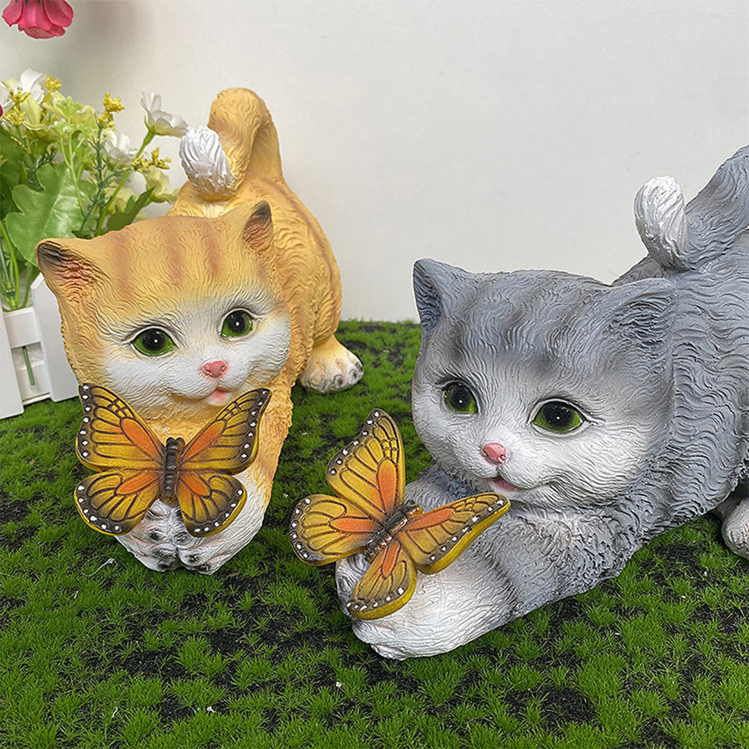 Pair of orange and gray kitten ornaments with light-up butterflies in garden setting