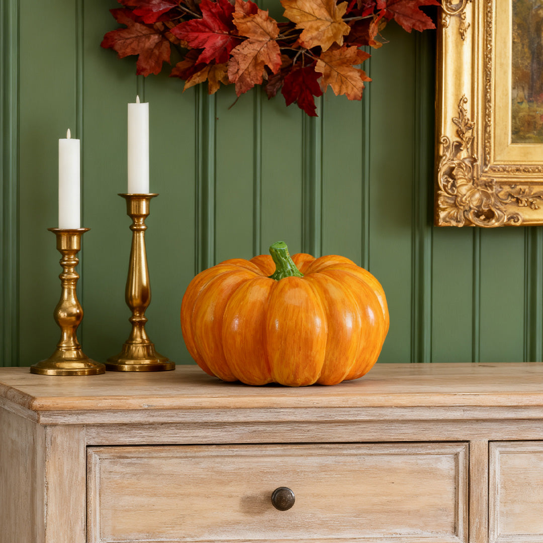 Orange halloween pumpkin light displayed as elegant autumn decor on a wooden console table.