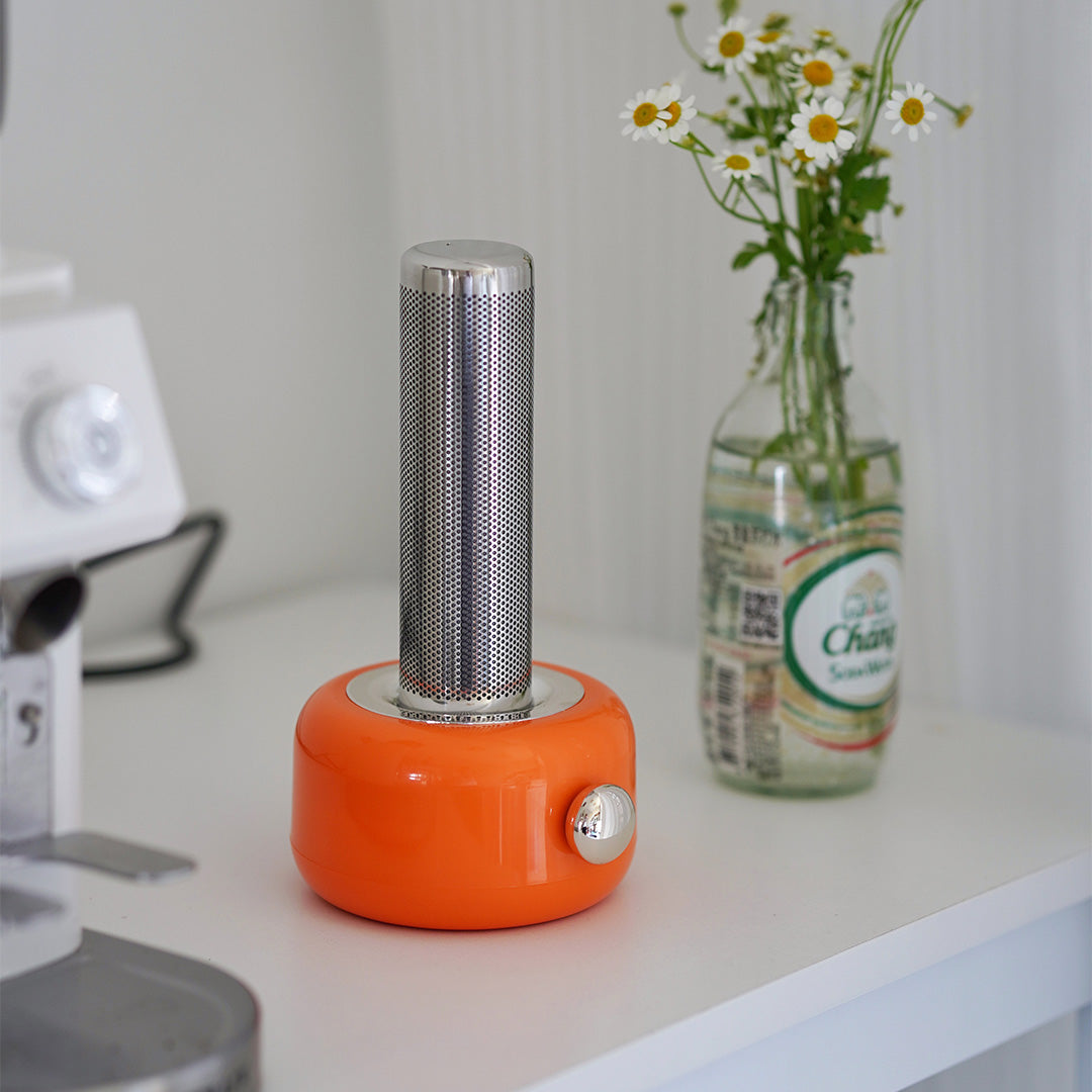 Orange industrial metal USB rechargeable table lamp with decorative flowers on white surface