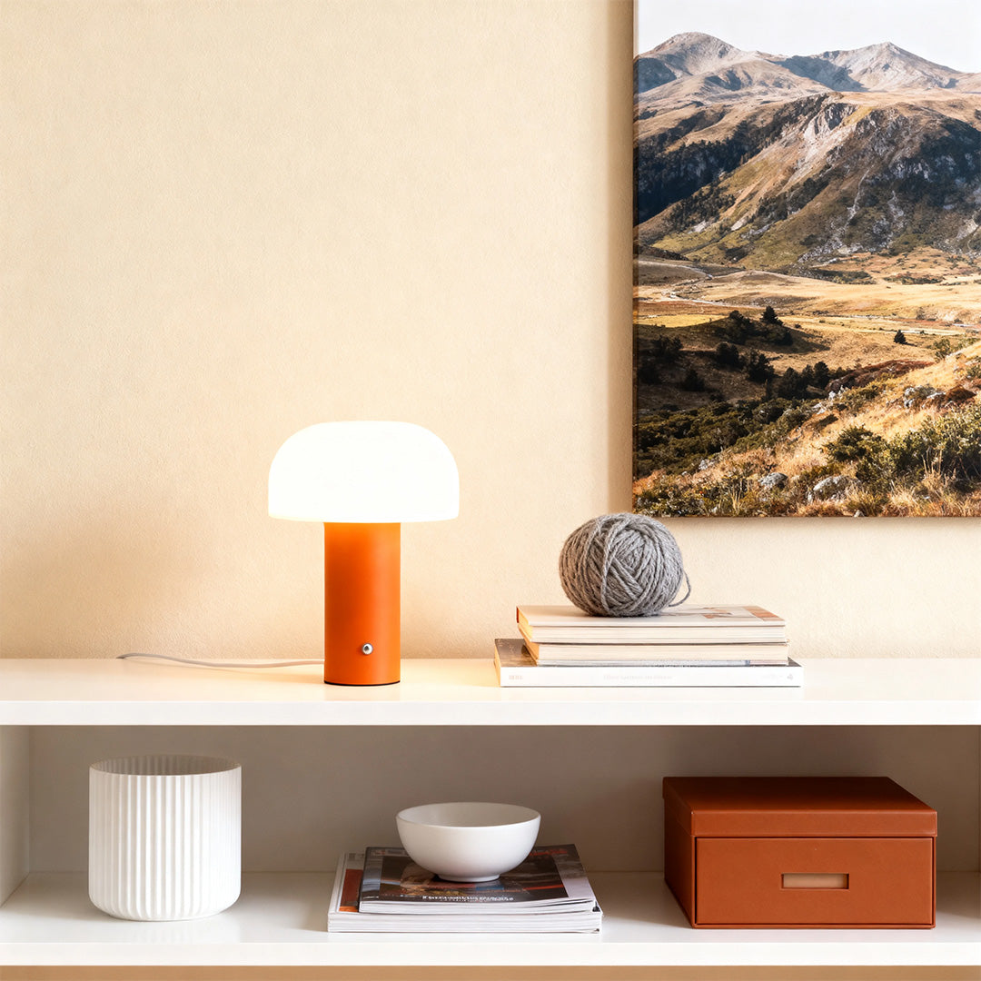 Orange novelty table lamps providing warm accent lighting on bedside table with decorative elements
