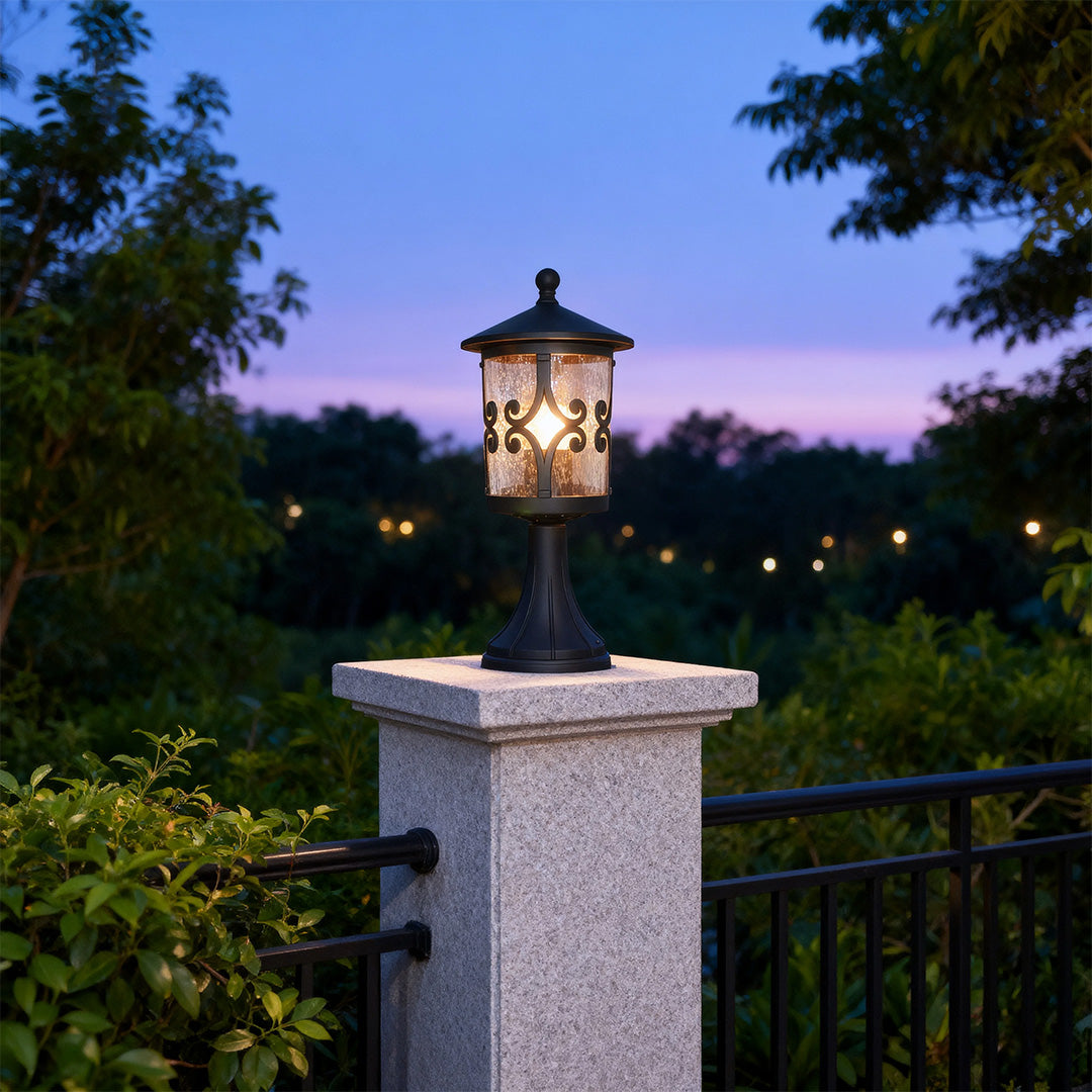 Ornamental porch pillar light providing ambient lighting on stone pier against purple twilight sky