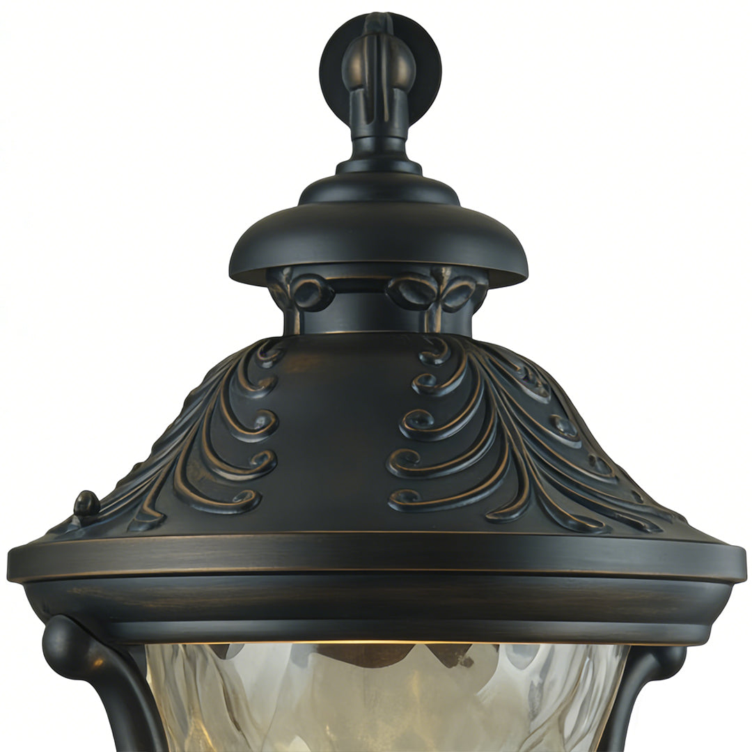 Ornate outdoor light wall fixture with intricate bronze detailing and finial, adding classic elegance to exterior home lighting.