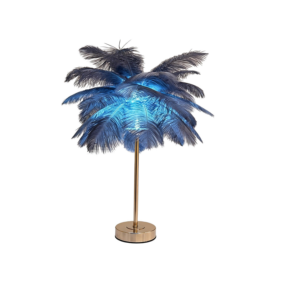 Ostrich feather table lamp with a gold base, placed on a white surface.