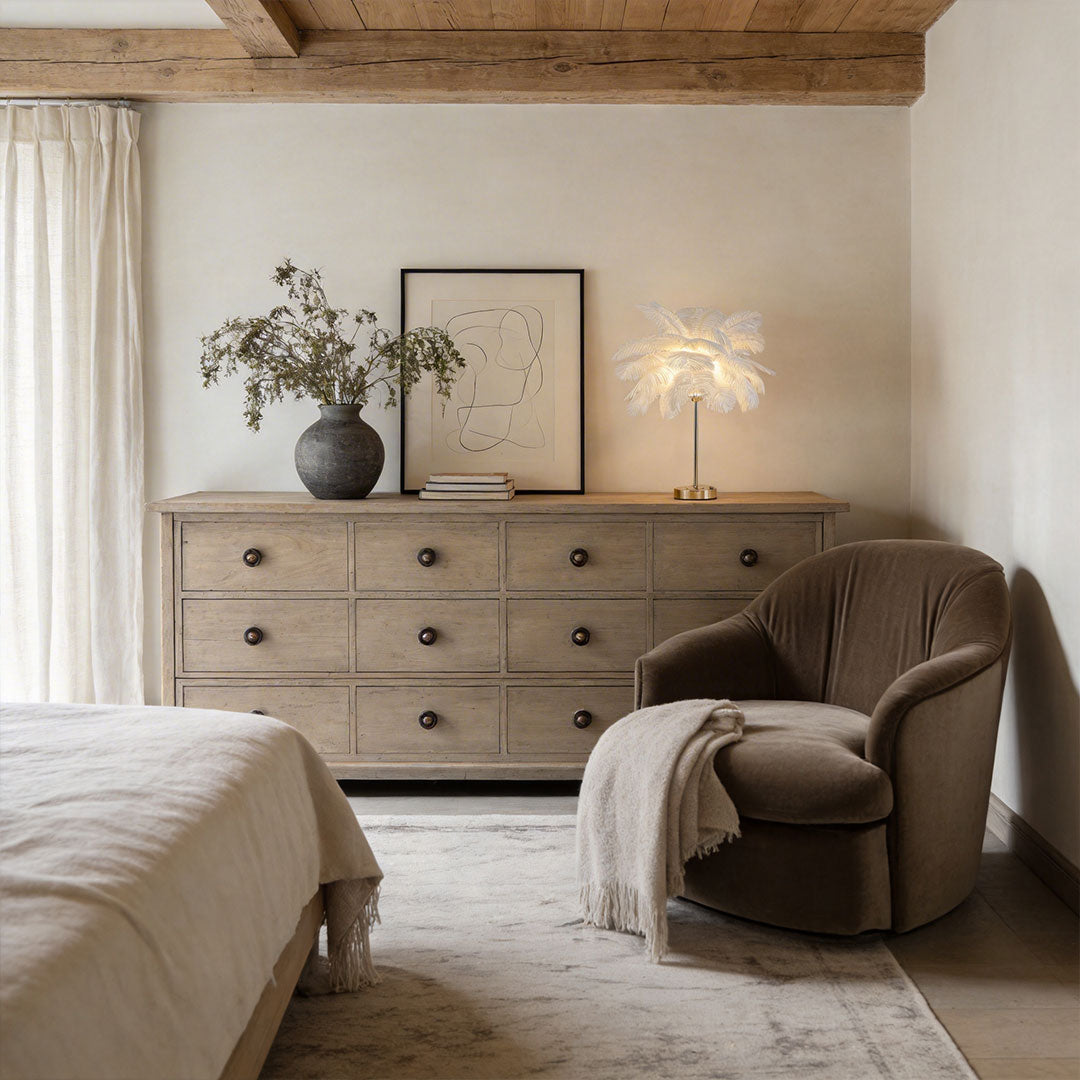 Ostrich feather table lamp with a white feather design, illuminating a stylish bedroom.