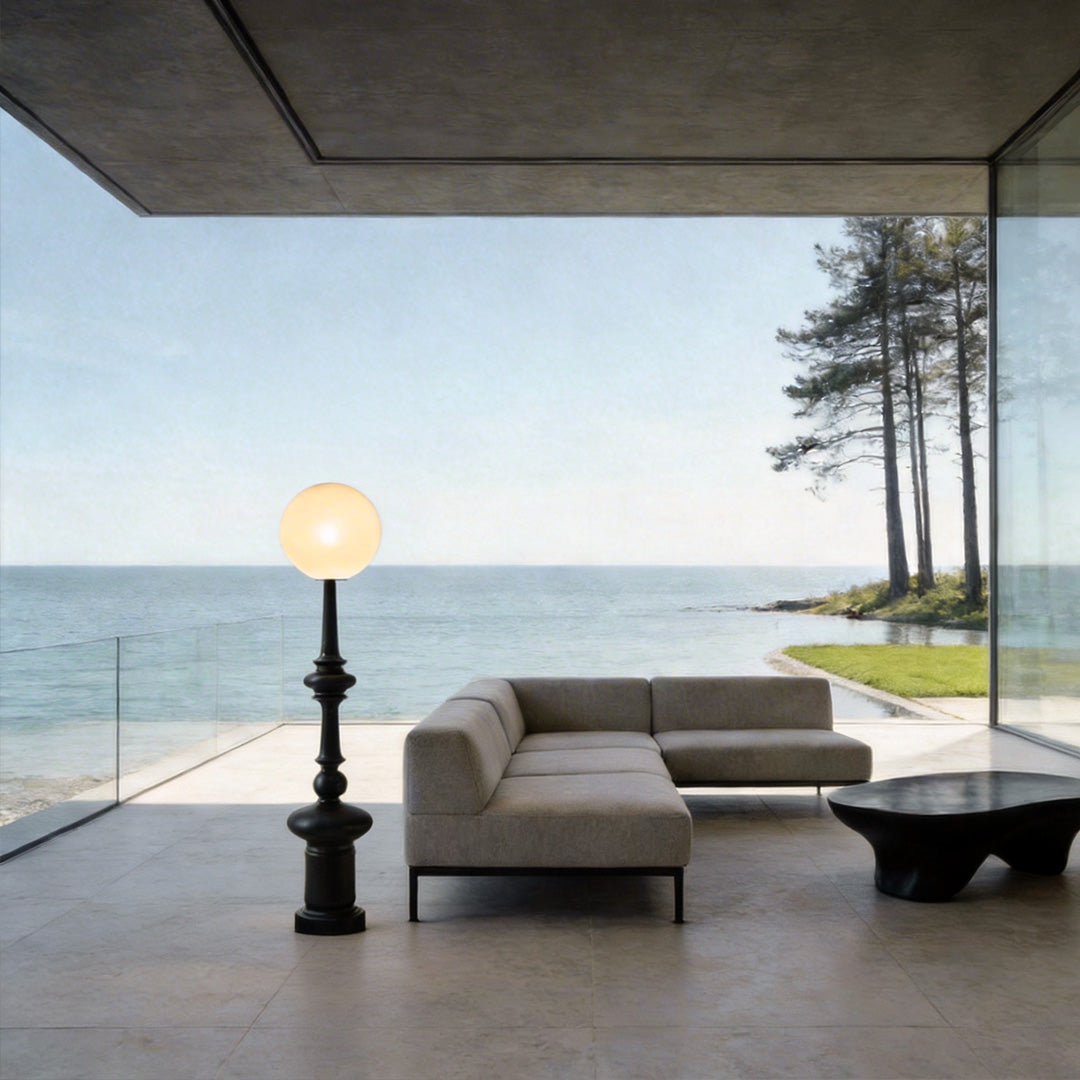 Outdoor black floor lamps with a modern design, illuminating a seaside lounge area.