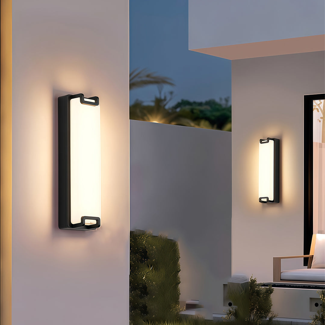 Outdoor black wall sconce, providing soft lighting on a dark exterior wall, perfect for modern outdoor spaces.