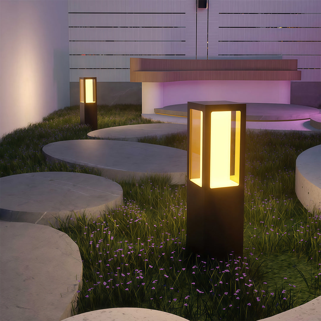 Outdoor bollard light placed near decorative stones, enhancing the outdoor ambiance with subtle lighting.