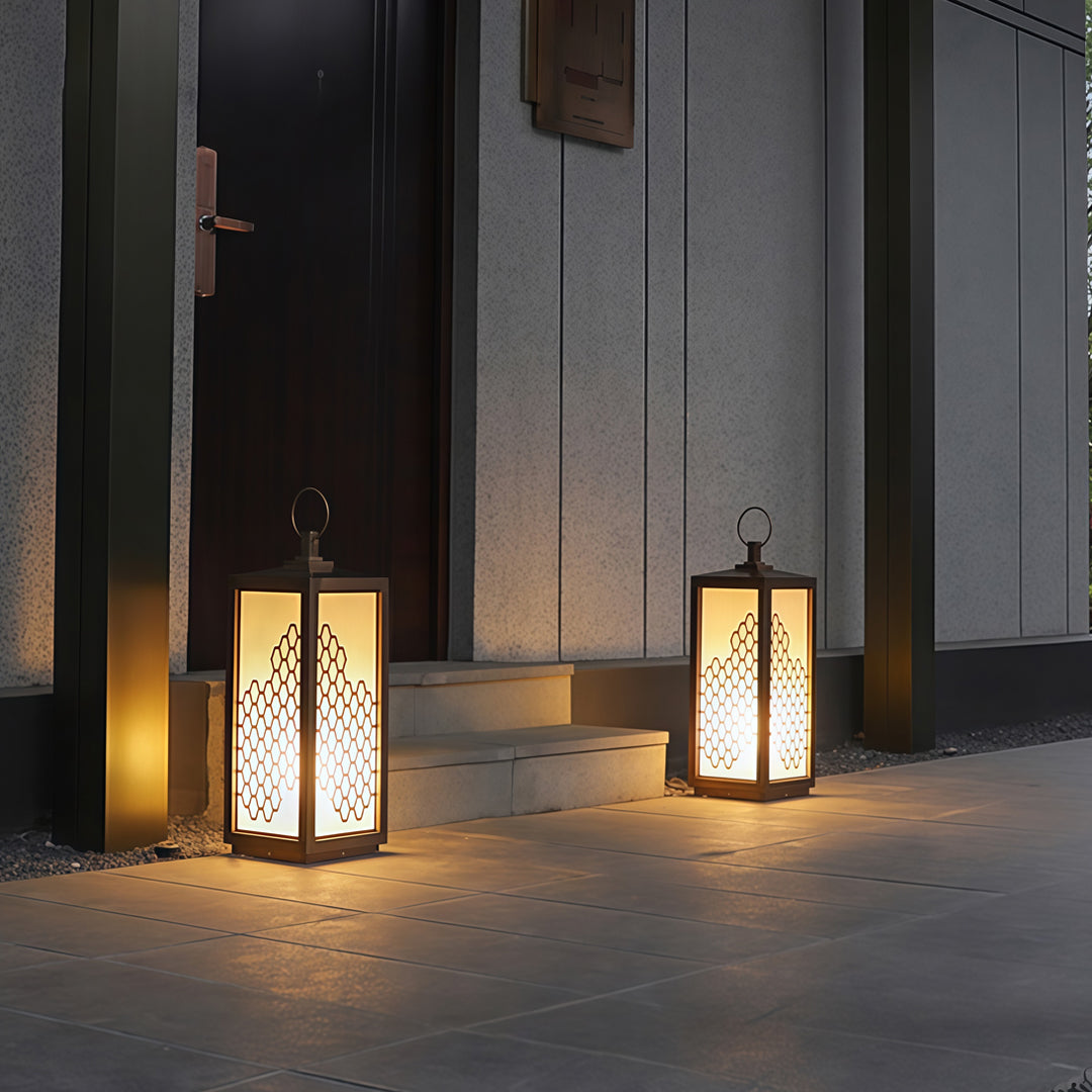 Modern exterior entrance illuminated by decorative lantern-style bollard lighting at night.
