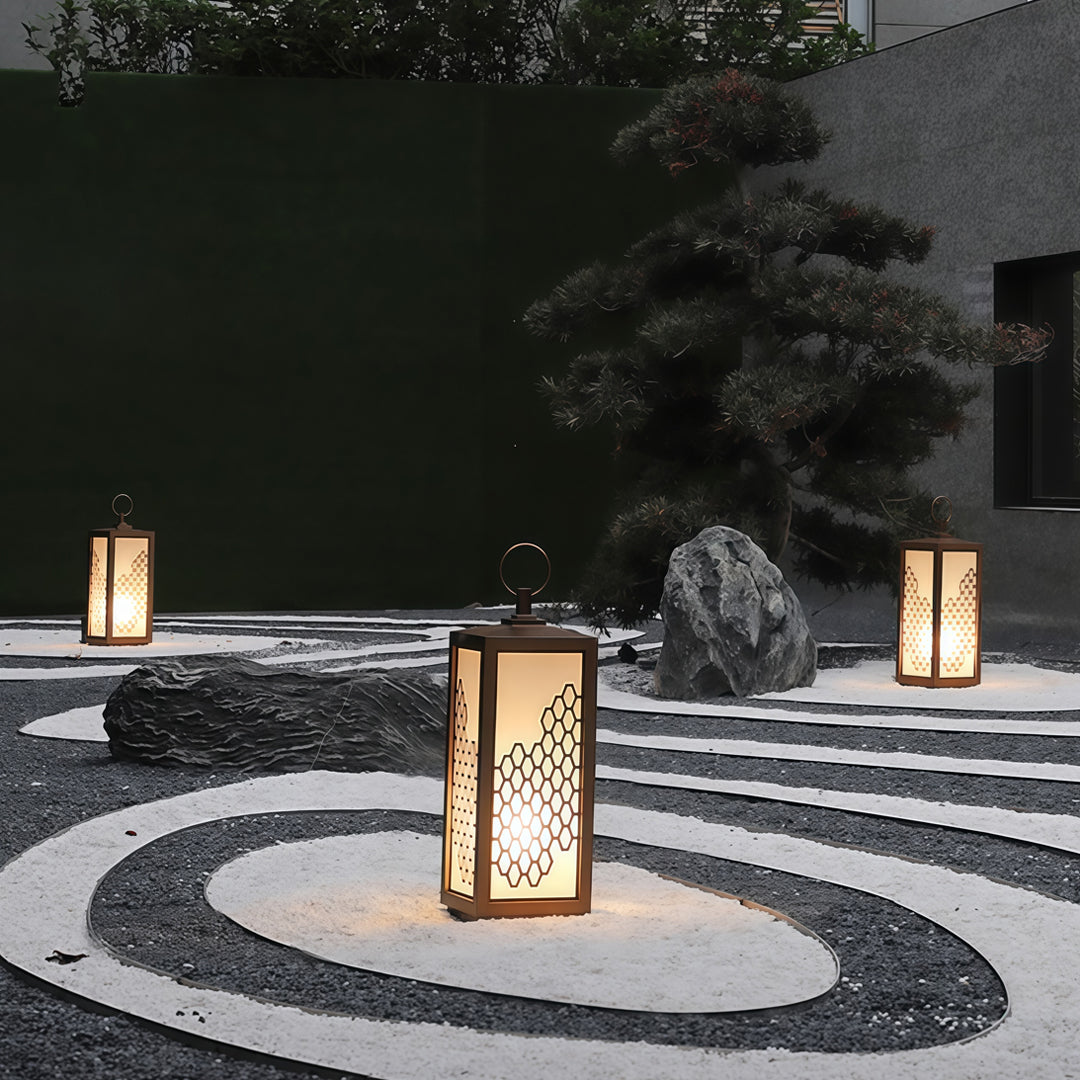 Outdoor pathway featuring standing lantern-style bollard lighting with warm illumination.