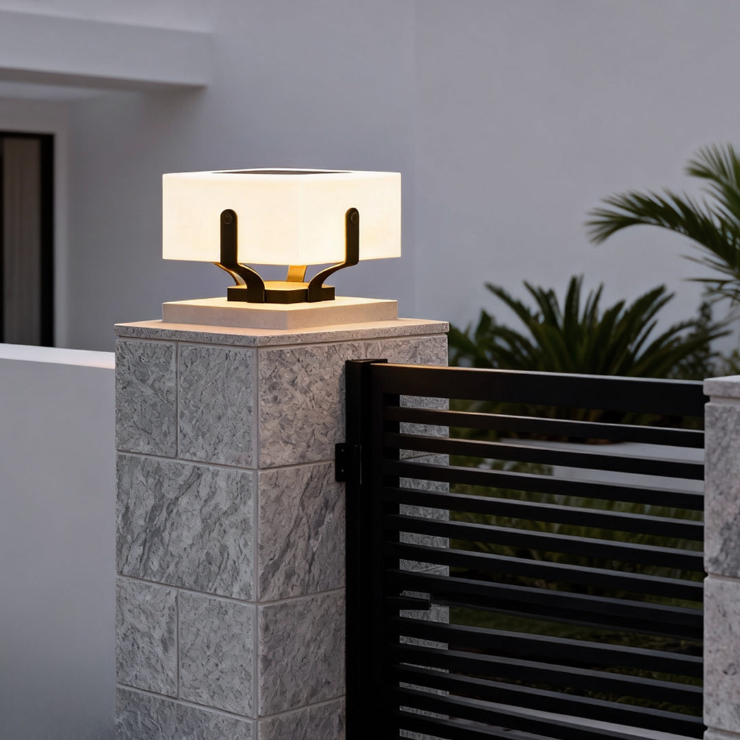 Outdoor brick pillar lights installed on a gray brick pillar, enhancing the entrance with warm light.