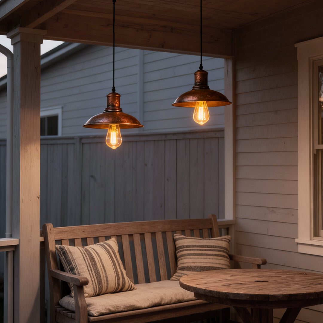 Outdoor bronze pendant lighting hanging from a porch ceiling, creating a cozy ambiance for seating.