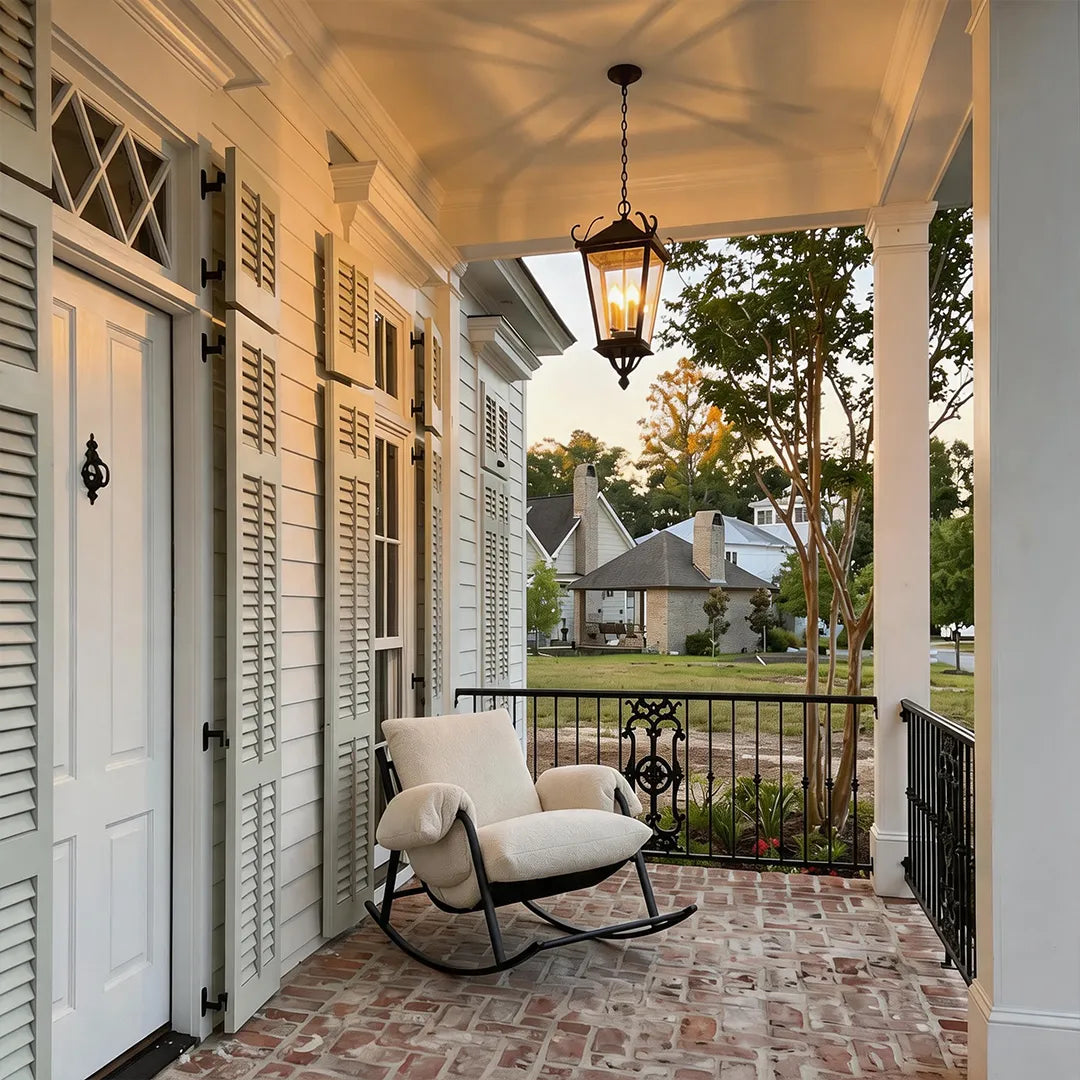 Outdoor ceiling pendant light suspended on a covered porch near a rocking chair, creating a warm and inviting seating area.