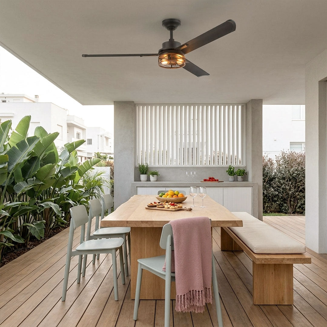 Black ceiling fan with lighting installed above an outdoor dining table in a covered patio.