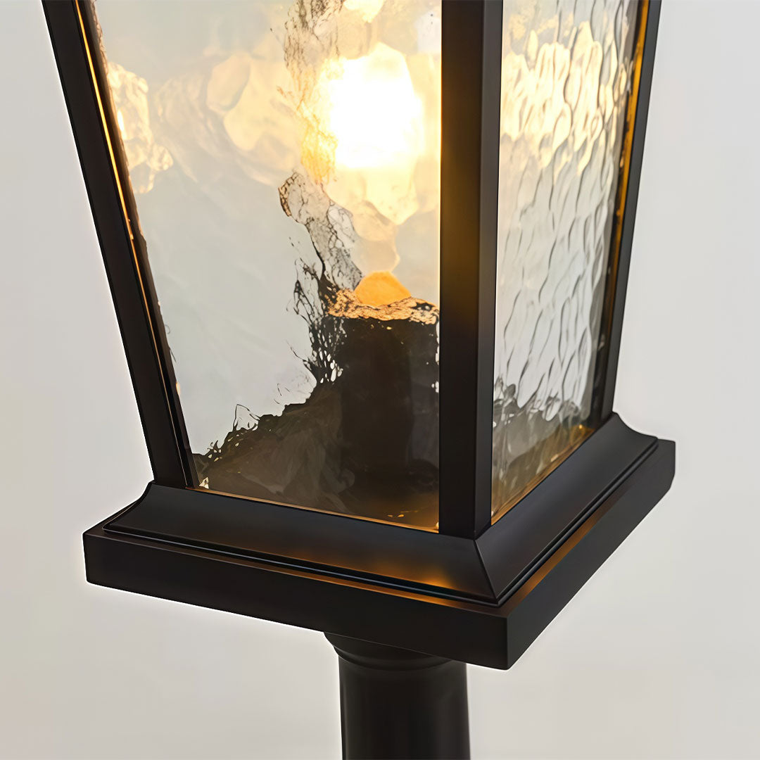 Outdoor driveway pillar lights with a classic design, mounted beside a landscaped garden.