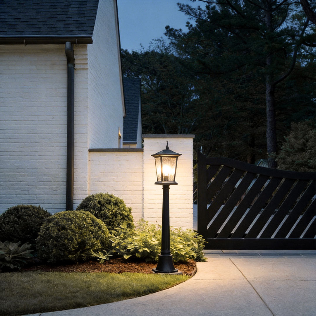 Outdoor driveway pillar lights with a classic design, illuminating a modern house entrance.