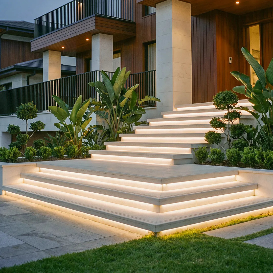 Outdoor embedded LED light strips integrated into modern entry stairs, providing warm accent lighting along each step edge.