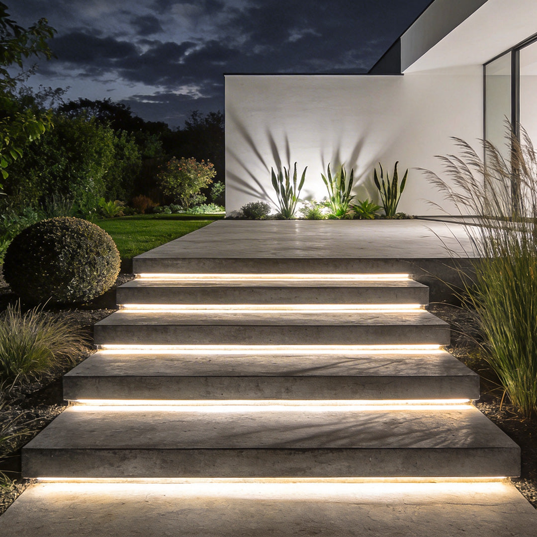 Outdoor embedded LED light strips installed along wide exterior stone steps, creating clean linear illumination at night.