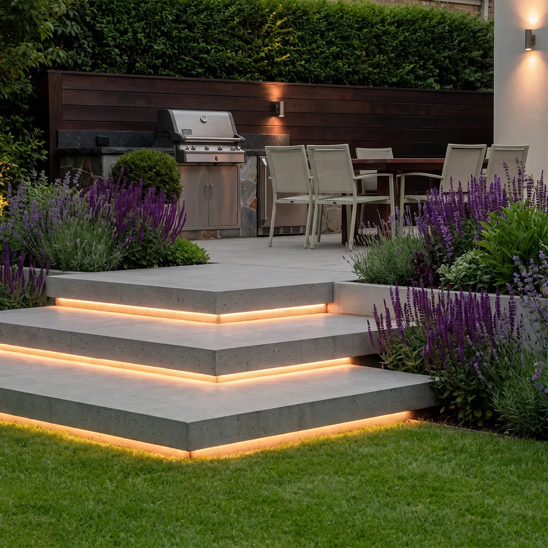 Outdoor embedded LED light strips built into tiered patio steps, adding warm glow around a landscaped backyard seating area.