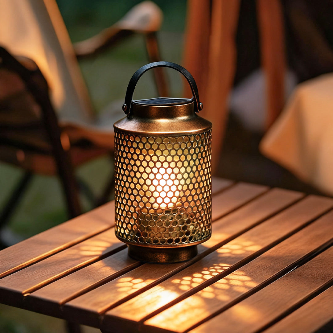 Portable solar lantern on a wooden table with warm illumination in an evening outdoor space.